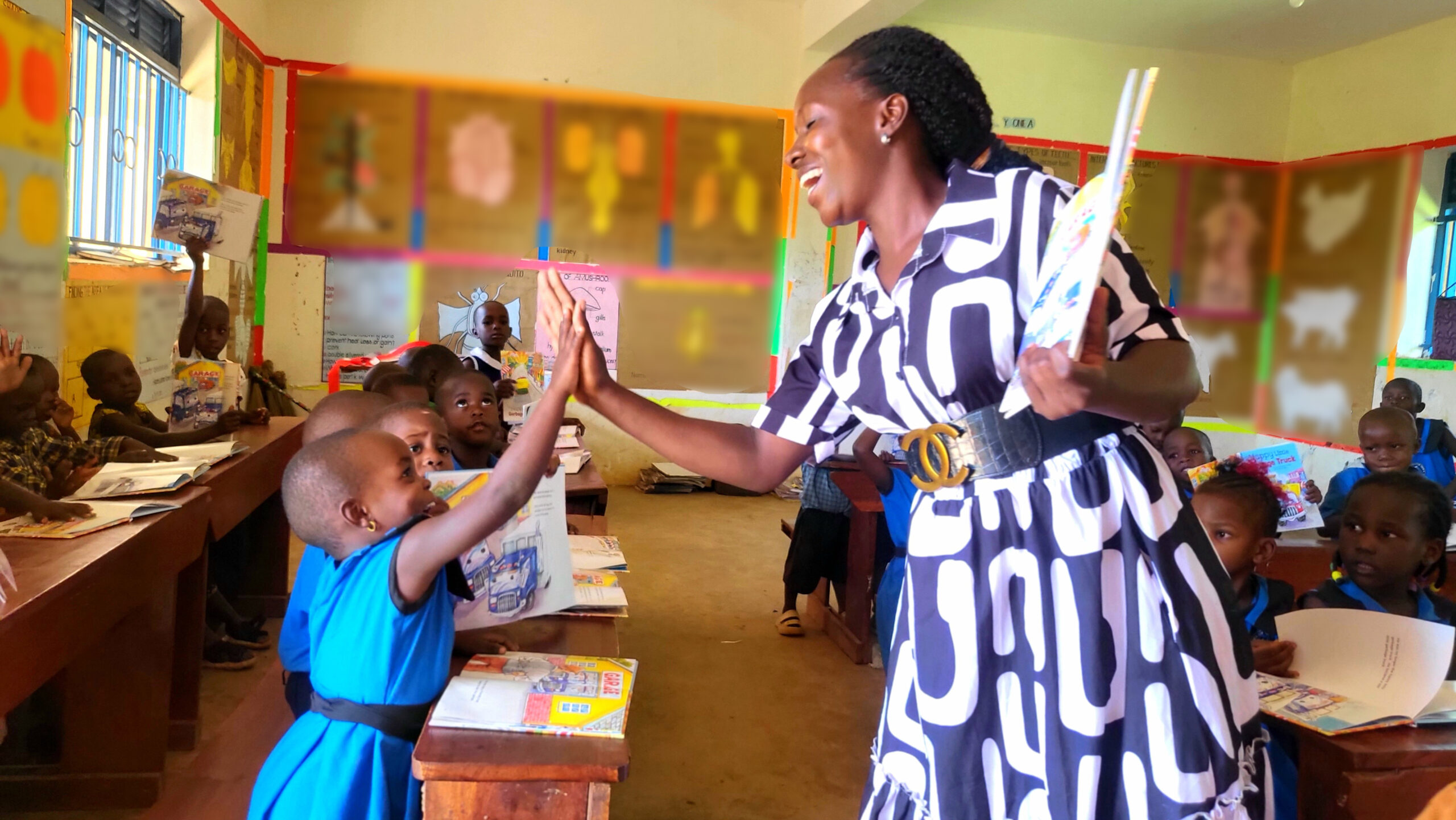 A teacher and young student celebrate with a joyful high-five in the FFYEC classroom