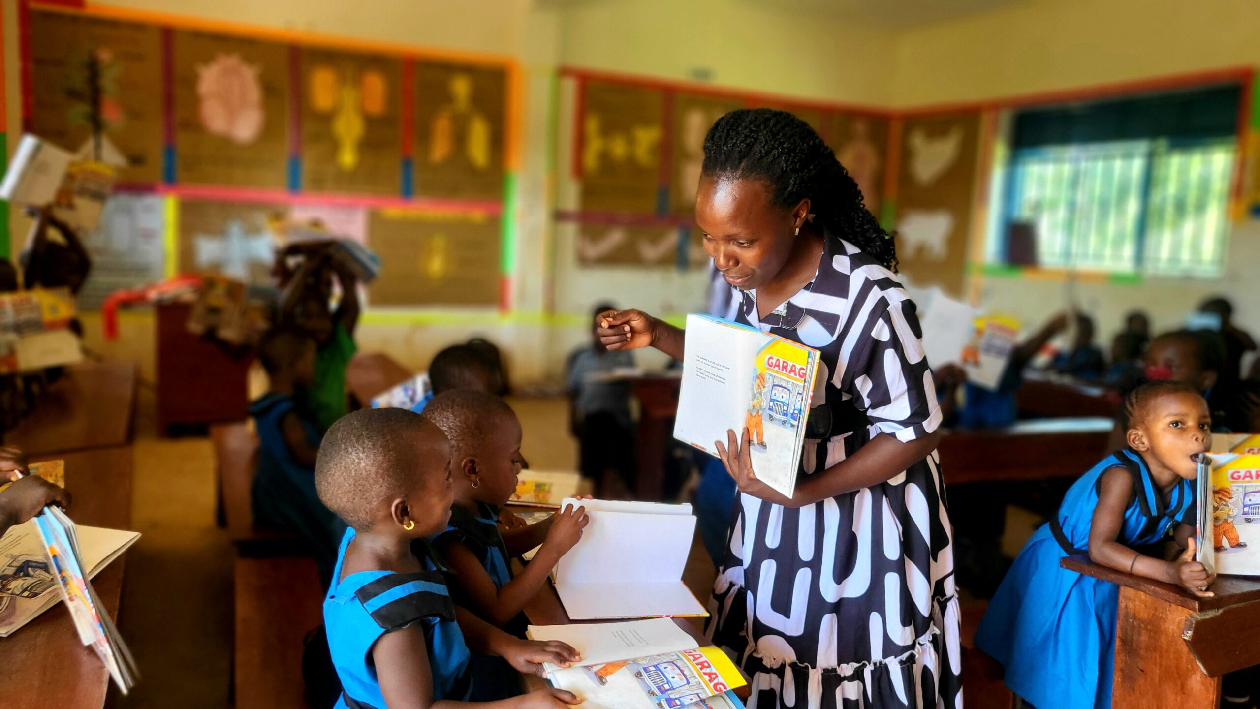 A teacher and young learner share an intimate reading moment, both looking at the same page