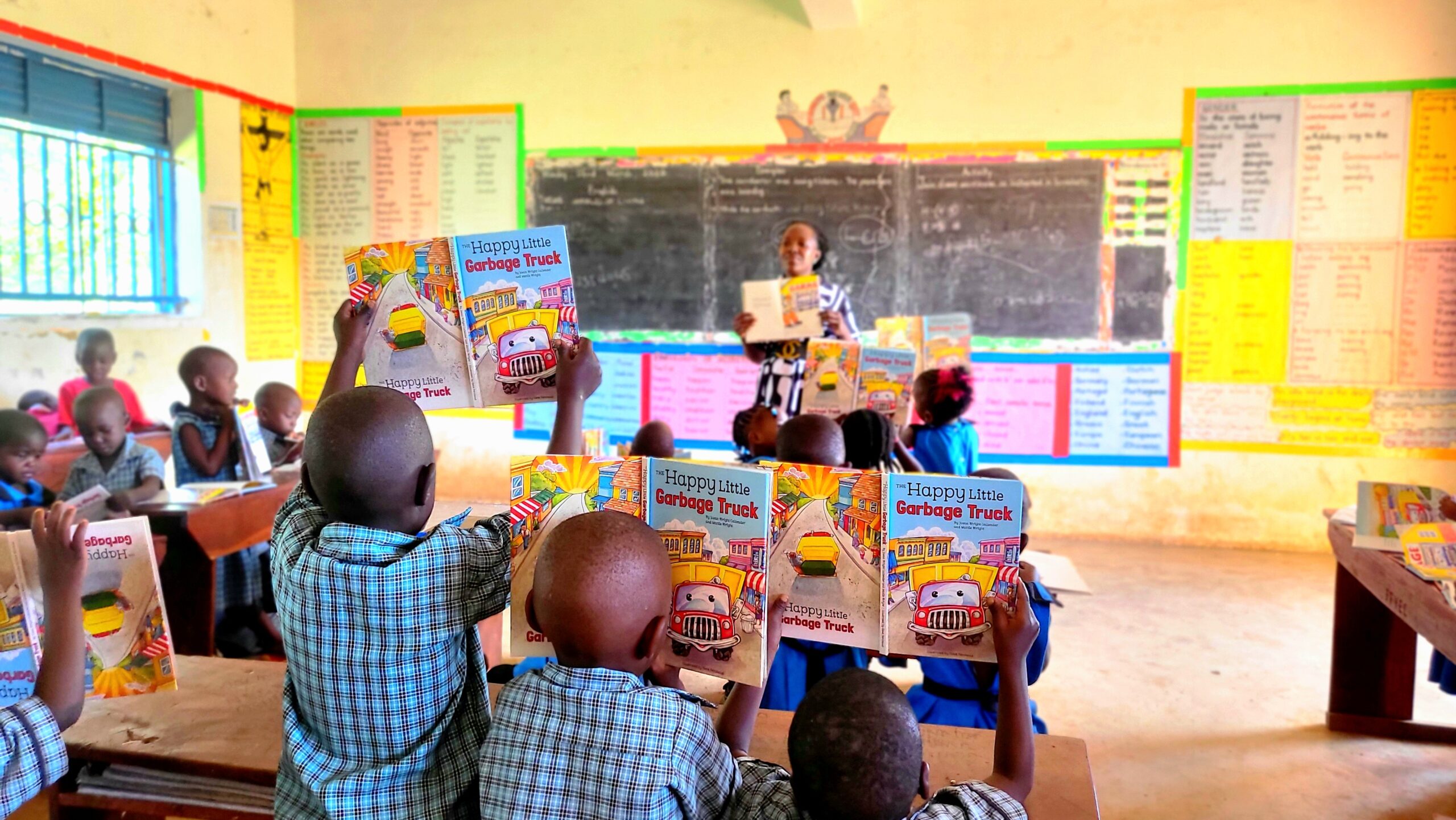 A wide classroom view — every student engaged, books open, teacher guiding from the front