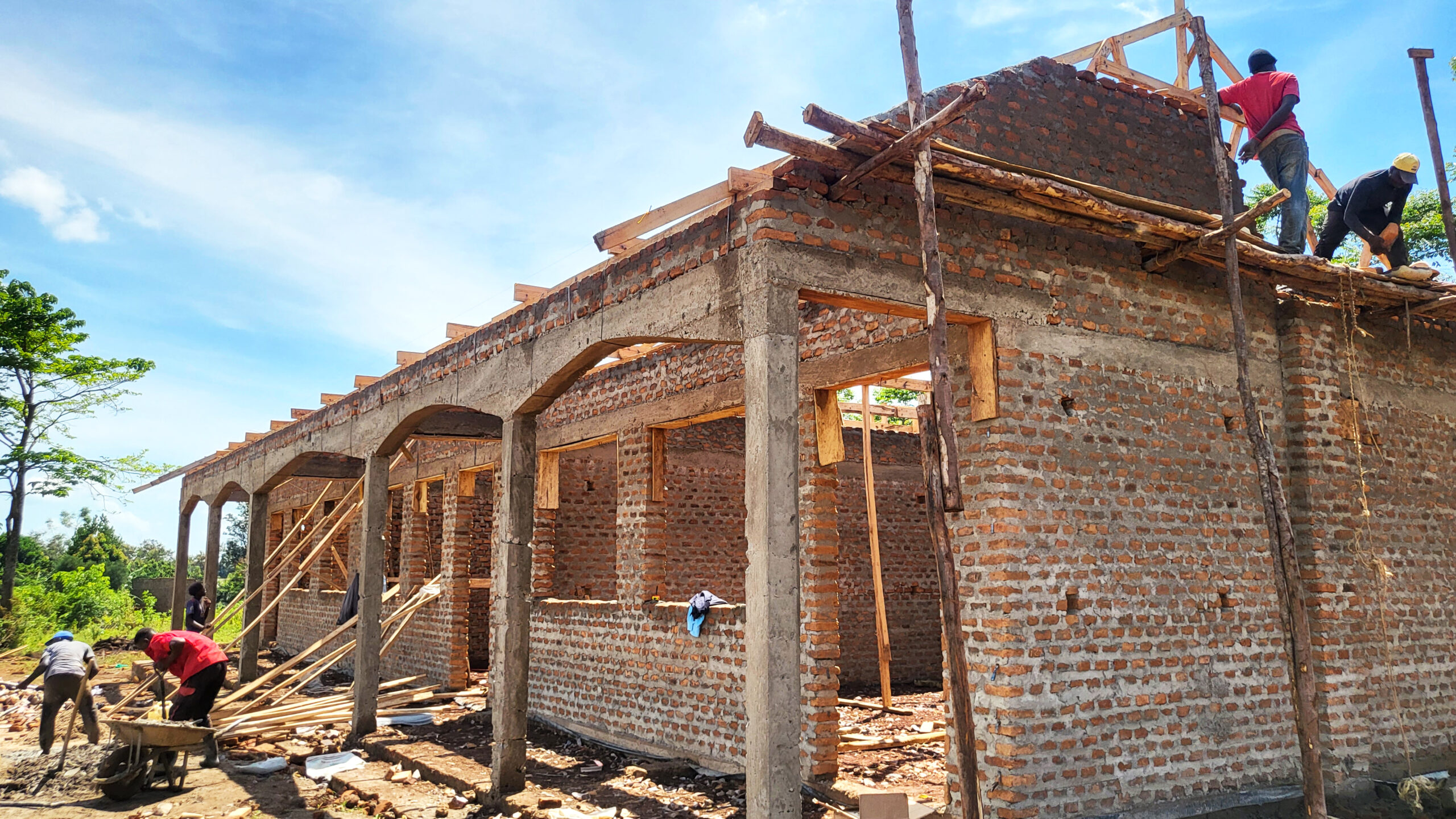 Workers active on the rooftop of the Technical Skilling Center Bugiri